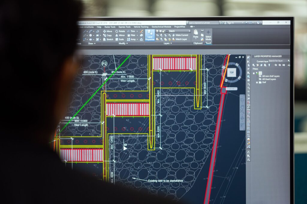 An industrial plant operator monitoring real-time SCADA system data on central control room screens.
