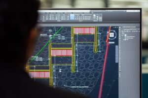 An industrial plant operator monitoring real-time SCADA system data on central control room screens.